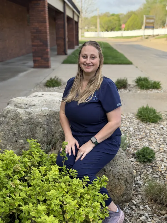 Monica, in navy Candlewood scrubs, outside the clinic